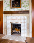 A detailed view of the fireplace and hearth in a portrait-style orientation. There are logs inside of the fireplace just waiting to be lit.
