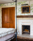 A sophisticated blend of white tiles with accents of our sunset-pink Blush Iridescent glaze set in a rustic-style bedroom scene with distressed wood mantle.