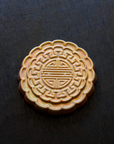 A Mooncake Paperweight in shimmering Blush Iridescent.