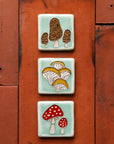 Hand-painted Morel, Oyster and Amanita mushroom tiles stacked vertically on deep, terracotta colored roof tiles.