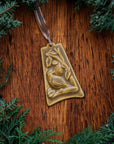 The bell-shaped Partridge in a Pear Tree Ornament features a partridge sitting on the branches of a tree with one large pear dangling from its branches. The ornament is glazed in a creamy brown color.
