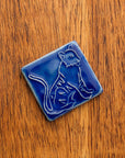 Glossy blue 3x3 Tigers Tile on a warm, wooden background.