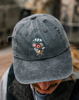 The dark gray Floral Hat features an embroidered bouquet of flowers in a brown and white vase.