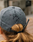 The back of the dark grap baseball cap features the embroidered Pewabic logo and an adjustable fabric strap.