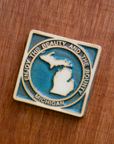 The viridian/scrape version of the Michigan tile is glazed in the crystalline deep green glaze called Viridian. Before firing, the tile has been scraped, leaving the raised design without color.
