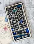 This rectangular Detroit Map Tile has a line drawing of the areal street view of downtown Detroit. The word "Detroit" is written at the bottom of the design.
