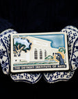Two mittened hands hold the Detroit Institute of Arts tiles on a black background.