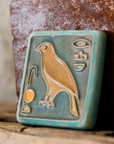 First designed in the 1920s, this hand-painted 3x3 tile depicts the bird hieroglyph Horus, the falcon-headed God of Light.