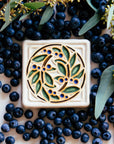 The hand-painted Style E features blue berries, green leaves, brown stems and a white background.