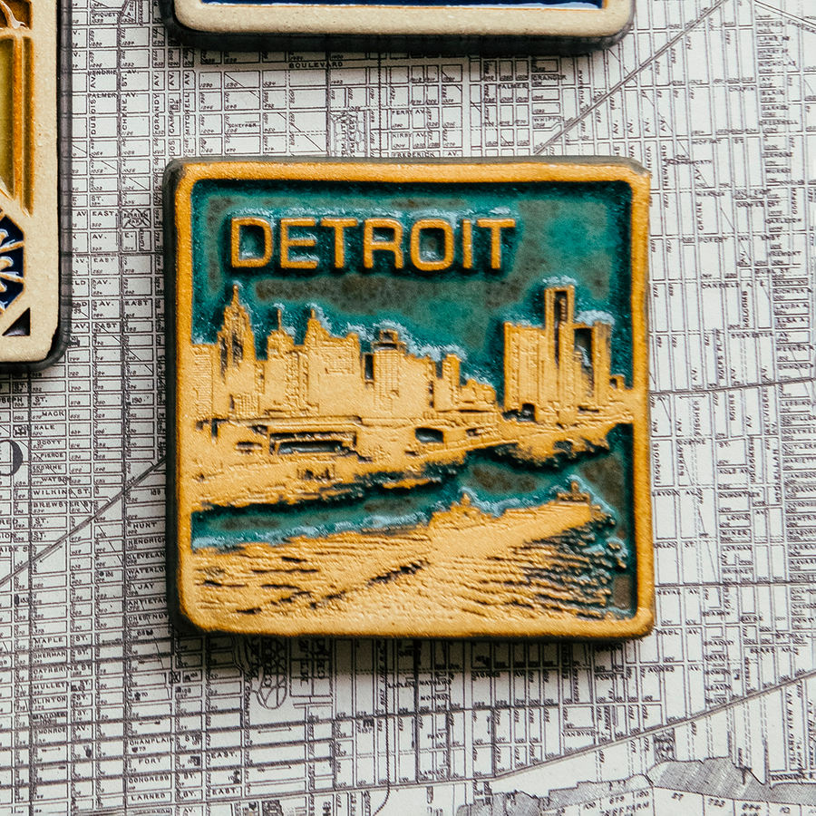 This two-tone Detroit Skyline tile is featured in the Viridian/Scrape color palette. The sky and water are in the crystalline, shimmering deep green Viridian glaze while the skyline, boat, and word have been scraped to create a creamy white color.