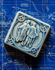 The Gemini tile in Celestite glaze sits on a vintage blue and white map of the celestial sky.