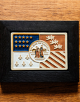 Our framed, hand-painted Detroit Flag Tile is laying on the historic Pewabic tiled floor in our upstairs gallery space. These tiles are a rustic brown and tawny in appearance.