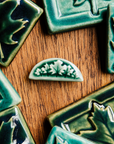 This pin features our glossy green Emerald glaze.