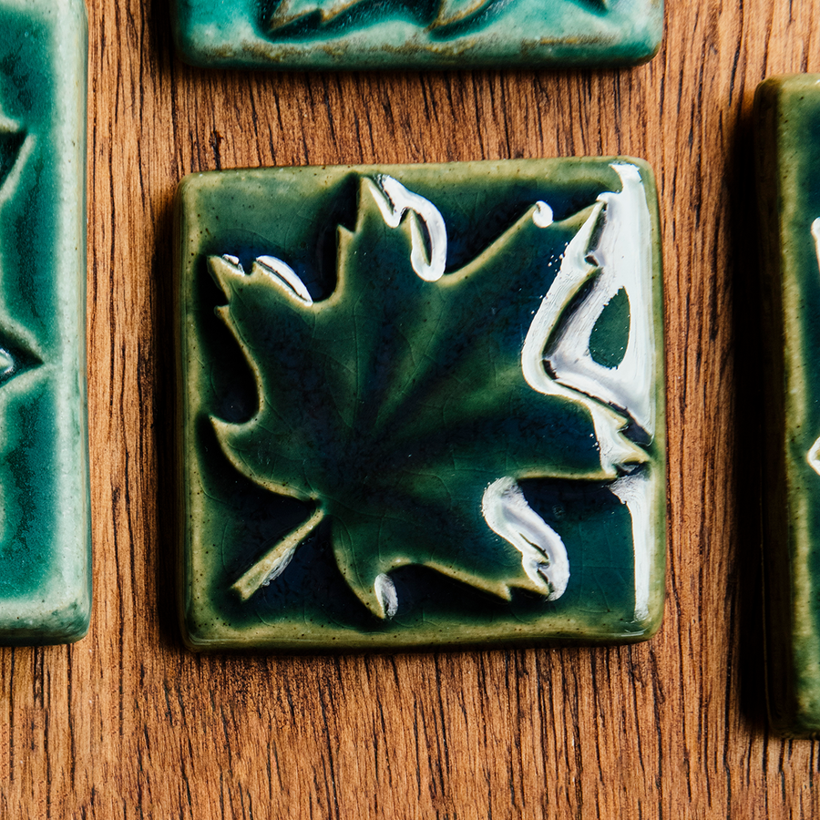The kale glazed maple leaf tile is featured. This tile is a deep glossy green.