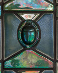 A close up shot of the featured Matte Green Iridescent Scarab nestled between matte-finished and Iridescent Aurora architectural tiles.