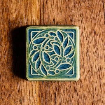 The raised portions of the tile are the matte bright light green Lime glaze while the background is the matte blue Lagoon glaze.