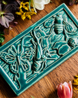The large Garden Life Tile features a teeming world of insects. A butterfly, ladybug, bee, praying mantis and ant move around grass and leaves. 