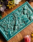 The large Garden Life Tile features a teeming world of insects. A butterfly, ladybug, bee, praying mantis and ant move around grass and leaves.
