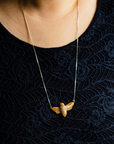 This necklace's chain has been adjusted to the longest length and hits mid-sternum. 