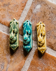 This ceramic Mezuzah features an acorn and oak leaf with the word "Peace" written in Hebrew below them. This piece is thick with an opening on the back to hold your written prayer. There are two holes at the top and bottom to make it easy to attach to your doorframe.