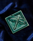 This Dragonfly Tile features the matte blueish-green Pewabic Green glaze on a rich blue velvet backdrop.