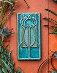 This vertical rectangle tile has an abstract low relief design. Interconnecting hard and curved lines come together to create a craftsman style motif.