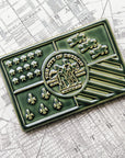 A Kale Detroit Flag Tile sits on a black and white street map of Detroit.