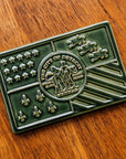 A Kale Detroit Flag tile rests on a wooden table.