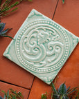 Thistles and greenery surround this Celadon Phoenix Tile.