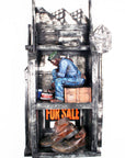 The top shelf is empty with harshly shaped metal that gives the impression of mountains at its top. The middle shelf holds a ceramic figure of a black man in denim work overalls and a green hat sitting on a wooden box as he ties his work boots. His shoe is resting on his lunch cooler that sits next to a thermos. The bottom shelf features a For Sale sign erected behind a pair of worn leather work boots.