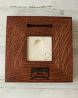 The back of the framed piece shows the open-back structure of the frame. This exposes the Pewabic Stamp one the back of the tile. There is a burned on stamp of the woodworker who created the frame- it says "Handcrafted Family Woodworks".