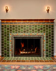 Warm chestnut glazed tiles make up the trim of this fireplace with bayleaf and assorted green glazed tiles at the center.