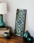 This Guardian Pattern Tile features glaze style B which includes multiple shades of glossy green with black accents.