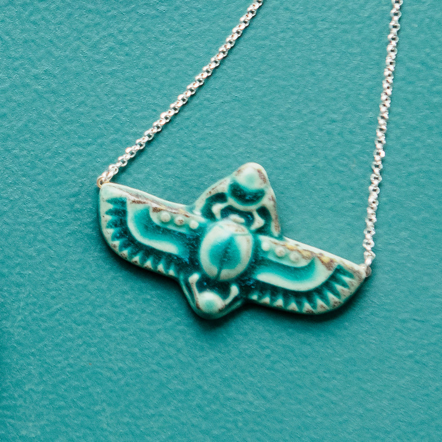 This scarab necklace features the matte turquoise Pewabic Blue glaze.