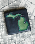 This hand painted tile has a dark matte black background with matte bright green peninsulas.