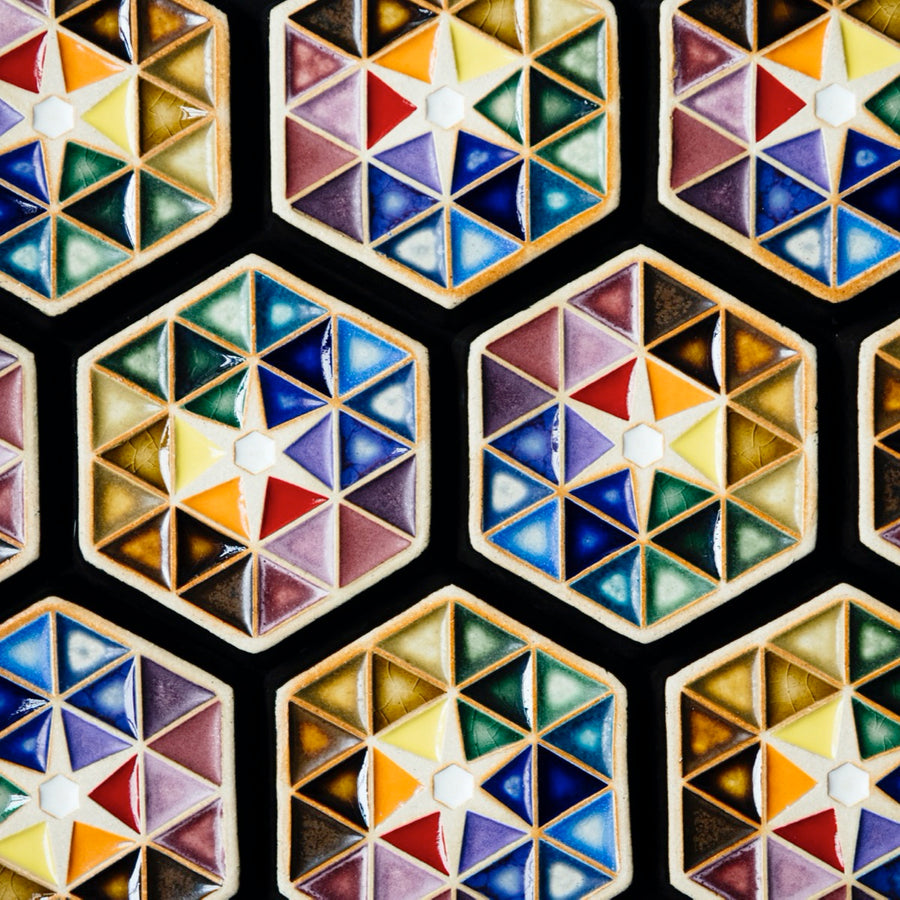Many Hex Paperweights are places together making an even larger pattern of colorful triangles.