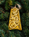 The bell-shaped Five Gold Rings Ornament features five intertwined smooth rings. There are springs of holly leaves and berries throughout the design. The ornament is glazed in a matte yellow glaze.