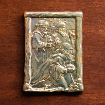 The Three Wise Men Tile features the wisemen in robes holding their three gifts- gold, frankincense and myrrh. They are all facing the right, they seem to be focused on one point beyond the tile. There is a stone wall behind them.