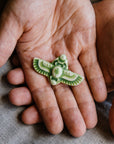 This high relief ceramic pin features a stylized scarab beetle with outstretched wings. The Scarab Pin featured is in our vibrant green-yellow "Lime" glaze.  