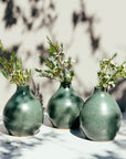 Three Teardrop vases sit together. They feature the matte mottled Greenstone vase that contains some sparse brown speckling.