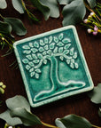 The Botanical Tree tile features a large tree motif with a line border around the tile edge. This ceramic Botanical Tree tile features the matte Pewabic Green glaze.