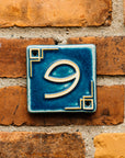 The Craftsman style ceramic 9 address number is in the matte blue Peacock glaze option.