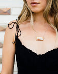 The Faceted Tile Necklace is a small rectangular tile with an asymmetrical four-sided pyramid raised on its surface. This Faceted Tile Necklace features the pinkish gold metallic Blush Iridescent finish which has many variations. Depending on the lighting in the room, these pieces will pick up different hues.