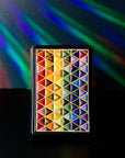 The 4x6 Pride Tile features lines of interlocking triangles, the colors on the triangles start at red and end in indigo- creating the rainbow Pride flag. The bright pattern is contained in a black border.