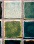 A detail of four tiles show that some are matte colors and others are glossy with crazing.