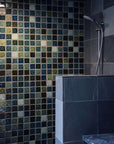 Further from the mosaic of color, there is a half wall with large dark gray marbled stone tile.