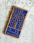 This rectangular Detroit Map Tile has a line drawing of the areal street view of downtown Detroit. The word "Detroit" is written at the bottom of the design.