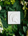 The Spartan Tile features a high relief design of a Spartan helmet with a large crest.