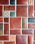 1:1 aspect ratio close-up shot of the red, tan, pine green, charcoal, and "blush" iridescent tiles in this autumnal design.