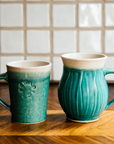 A photo comparing the Cafe Mug and the Classic mug shows that the cafe mug is slightly shorter than its Classic rounded counterpart.